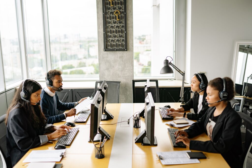 call center with four people typing and wearing voip headsets