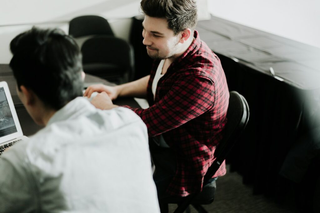 IT support technician helping an employee at a laptop